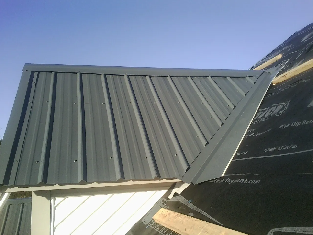 Gray metal roof panels going on over a garage gable in Monaca