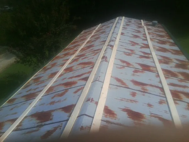 Rusted metal roof panels with new wood purlins before replacement — Storm Damage Roof Repair in Monaca by Roofing Brothers