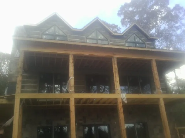 Dormers and porch framing on a large log home under construction — Roof Coating work by our crew in Monaca