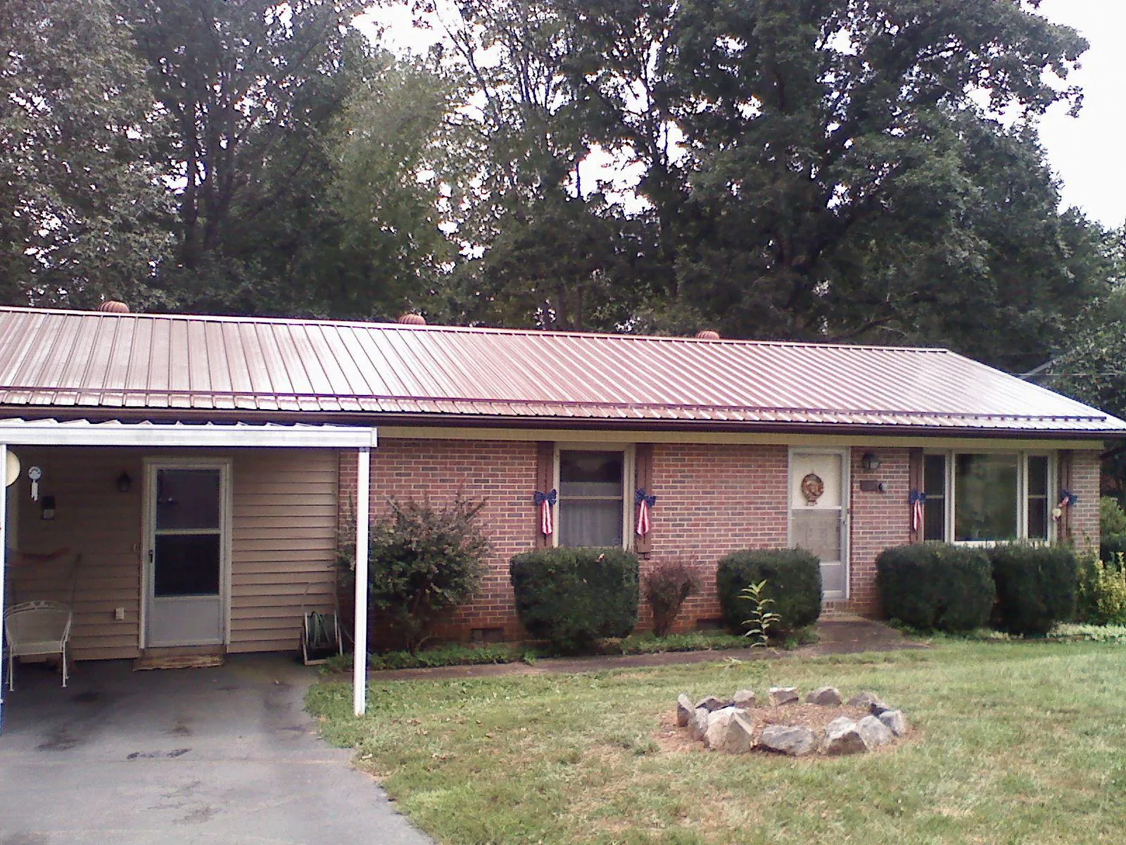 Bronze metal roof and carport on a brick ranch home — Roof Repair work by our crew in Monaca